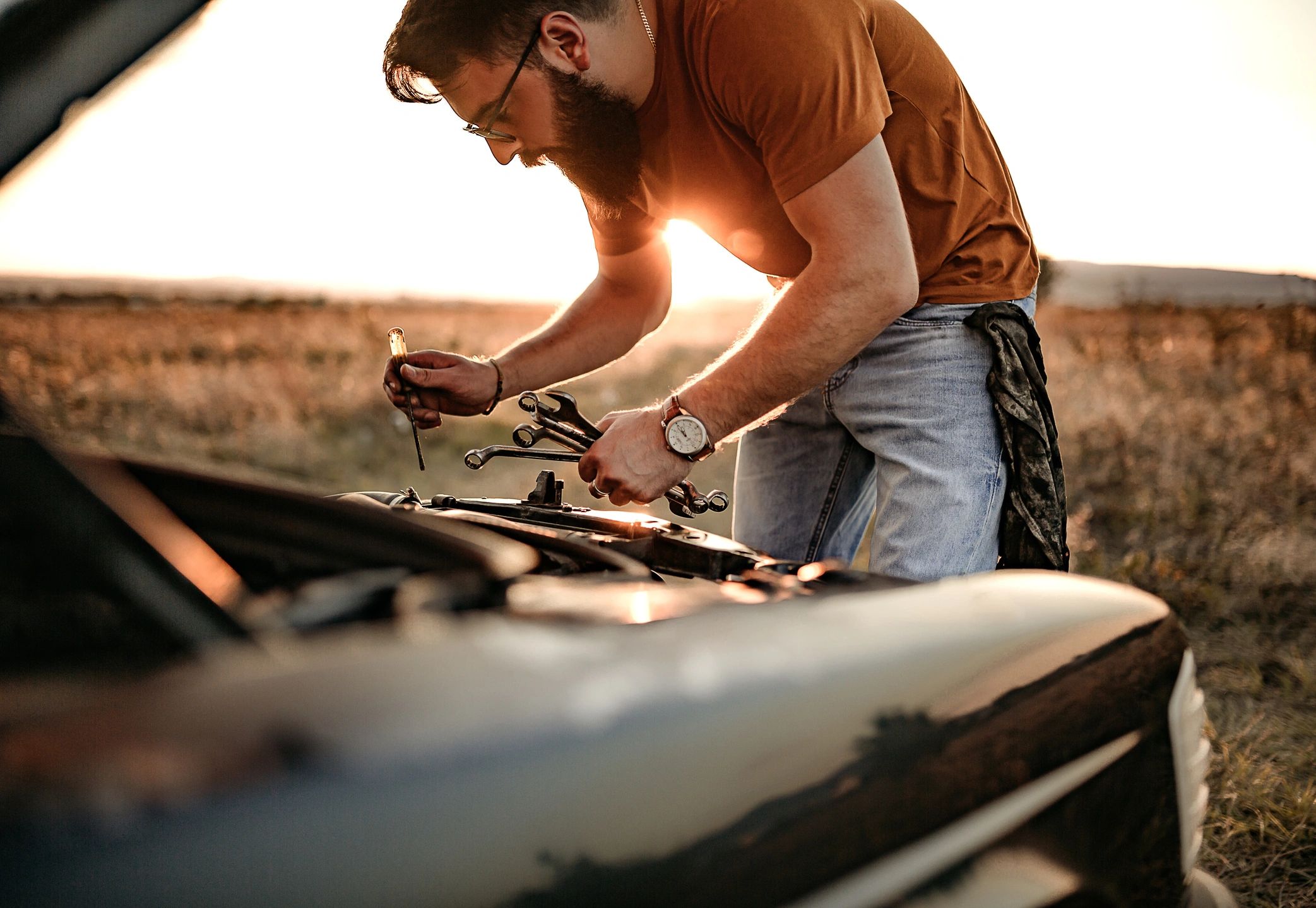 mobile mechanic repairing classic muscle car outdoors